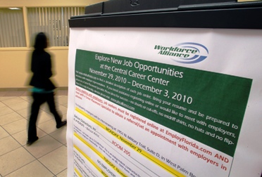 A job seeker walks past a sign at the Workforce Alliance Career Center in West Palm Beach.