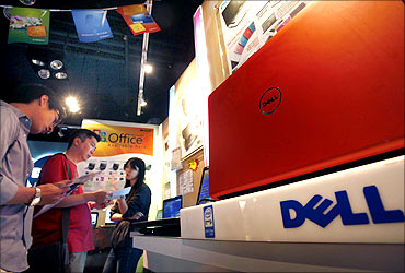 Customers examine Dell laptop models at a Dell outlet in Hong Kong.