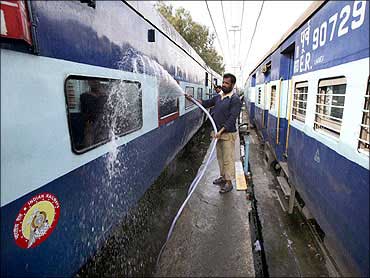 Railway employees wash a passenger train at a railway station in Jammu.