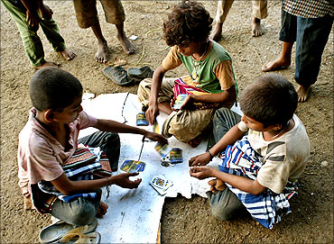 Street children play cards in a park in Mumbai.