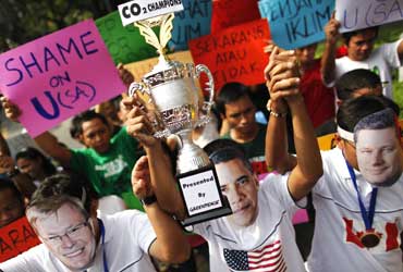 Greenpeace activists wearing masks hold a carbon dioxide champions trophy.