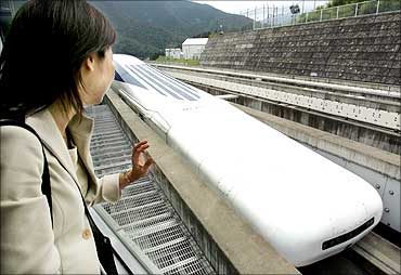 A Japanese woman looks at Central Japan Railway Co.'s Maglev train, which is levitated and propelled by magnetic forces, at an 18.4 kilometre test track of in Tsuru, west of Tokyo.