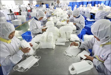 Employees pack newly made face masks at a factory in Rizhao, Shandong province.