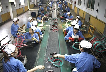 Employees make fuses at a dynamite production line of a chemical plant in Huaibei, Anhui province.