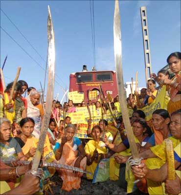 Activists from the Rashtriya Mahila Brigade (National Women's Brigade) hold swords and sticks as they block a railway track during Bharat bandh in Patna.