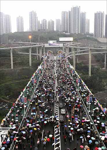 People walk on the Caiyuanba Yangtze River Bridge, in Chongqing municipality.