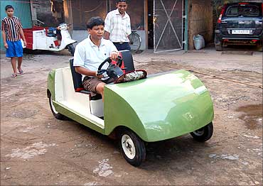 Kanak Gogoi in a car that runs on compressed air. His other innovations include a flying car, a hybrid car, etc.