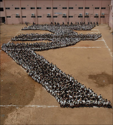 School students form the rupee symbol.