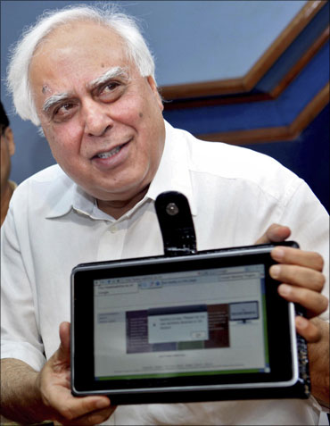 HRD Minister Kapil Sibal displays the low-cost computing device during its unveiling in New Delhi.