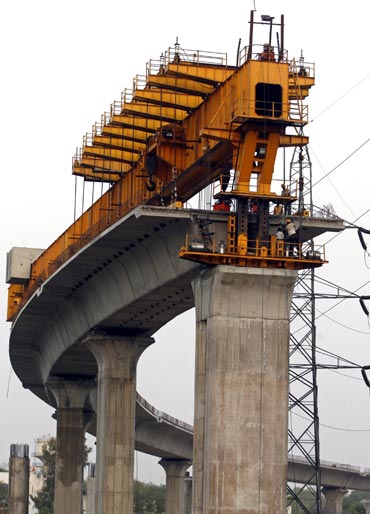 Delhi Metro Rail Corporation employees work at the construction of a flyover in New Delhi.
