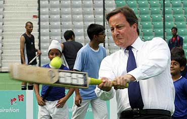 Cameron plays cricket inside a stadium in New Delhi.
