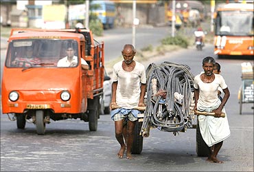 Labourers pull a handcart loaded with iron rods to a road construction site in Kolkata.