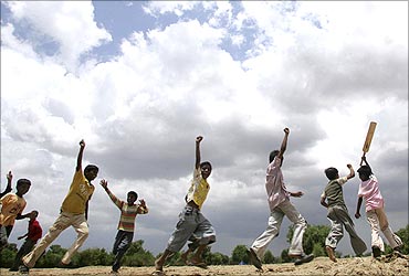 Children play as the monsoon clouds cover the sky in Ahmedabad.