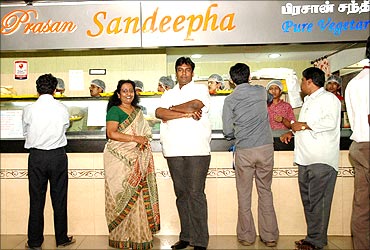 Patricia with her son Praveen in front of the Sandeepha restaurant.