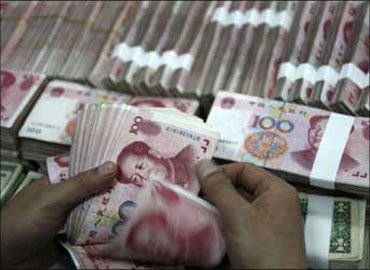A Chinese bank teller counts currency.