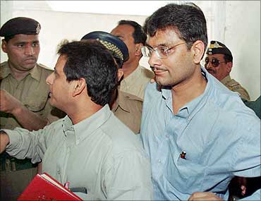 Ketan Parekh (R) is escorted into a courtroom by Central Bureau of Investigation officers in Mumbai in March 2001.