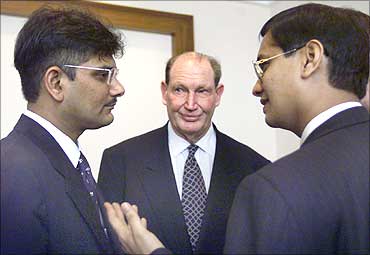 Australia's tycoon Kerry Packer (C) watches business partners Ketan Parekh (L) and Vinay Maloo (R) discuss a point during a news conference in Mumbai in March 2000.