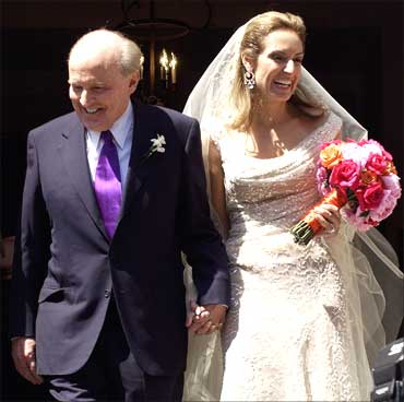 Jack Welch (L), walks down the steps of Park Street Church with Suzy Wetlaufer after their wedding in Boston, Massachusetts, April 24, 2004.