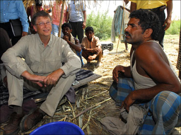 Microsoft co-founder Bill Gates (left) interacts with a villager in Aulali village, in Khagaria dist
