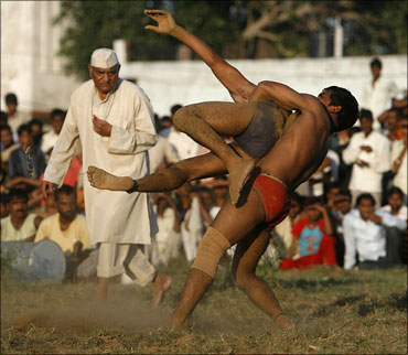 Indian wrestlers grapple with each other at an exhibition match.