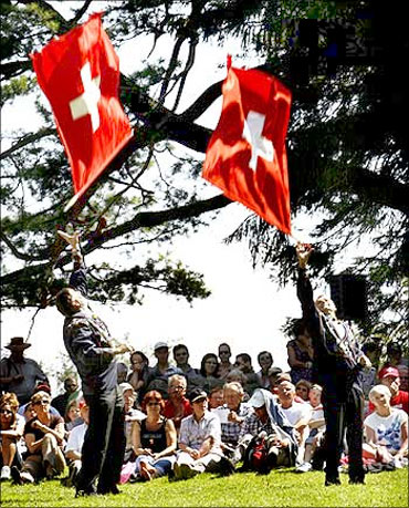 Traditionally dressed men take part in flag tossing during Switzerland's holiday celebrations.