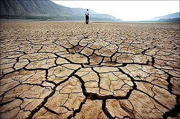A Chinese man walks on a dried-up riverbed at Huangyangchuan reservoir in Lanzhou.