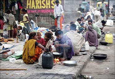 Homeless people prepare their food on a roadside in Ahmedabad.
