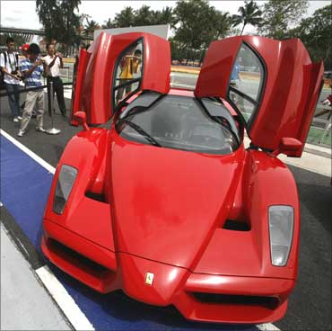 Visitors look at a Ferrari Enzo during a display of luxury cars in Singapore.