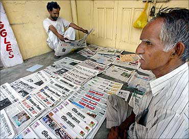 A newspaper vendor waits for customers on a street in Jammu.