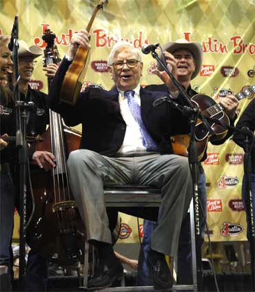 Buffett waves his ukulele with The Quebe Sisters Band.