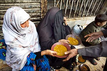 Women receive free food outside a restaurant in Karachi.