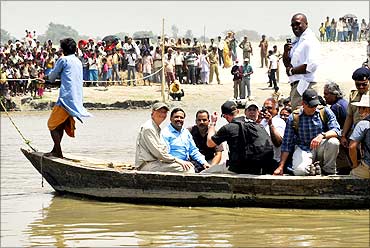 Microsoft Corp co-founder Bill Gates (front 2nd L) sits in a boat as he crosses river Kosi in Bihar.