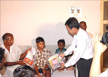 Posco official hands over books to children.