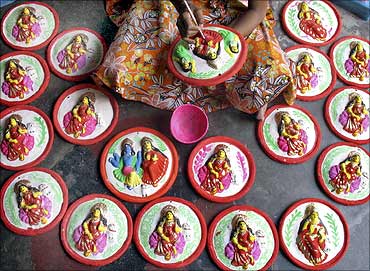 Shampa Pal, a potter, paints the Hindu goddess of wealth and prosperity Lakshmi.