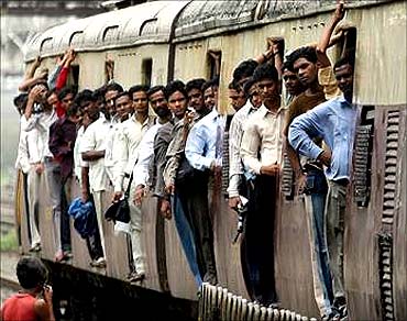 People go to work in a Mumbai local train.