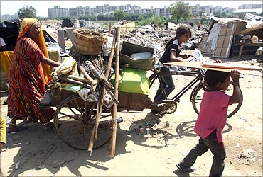 A family carries their belongings in a cycle rickshaw after they salvaged them from the debris.