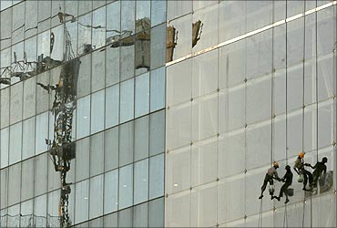 Workers clean the window of a building.