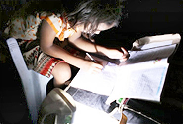 A child studies with a solar lamp.
