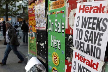 A man walks past newspaper headlines posted on a news stand on O'Connell Street, Dublin.