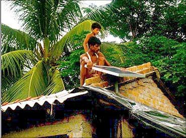 A villager installs a solar panel on the roof.