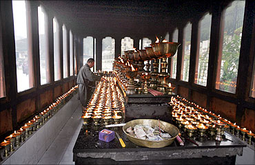 A Bhutanese man lights butter lamps inside a temple in Thimphu.