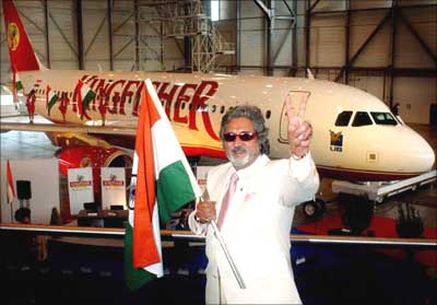 Vijay Mallya pose beside a Kingfisher aircraft.