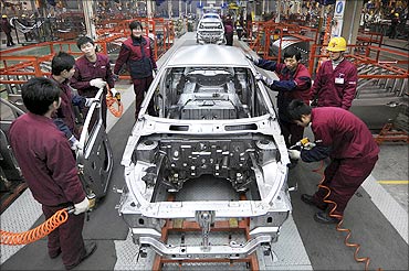 Employees work on the assembly line of Anhui Jianghuai Automobile Co.