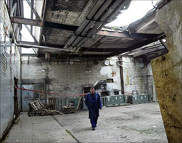 An idle worker walks through a damaged hall of the Sarabon chocolate factory in Sarajevo.