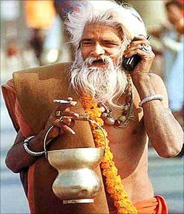 A sadhu speaks on his phone at Kumbh Mela.