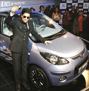 Shah Rukh Khan poses with Hyundai's i 10 electric car at India's Auto Expo in New Delhi.