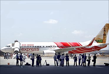 Journalists look at a new Boeing 737-800 aircraft in the livery of Air India Express at Mumbai airport.