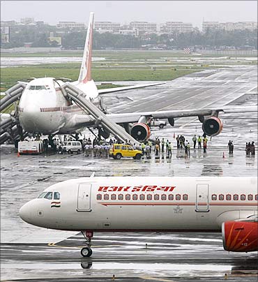 Air India's Boeing 747 aircraft (rear) stands on the tarmac after one of its engines caught fire.