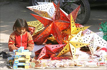 A girl selling Christmas decorations waits for customers in New Delhi.