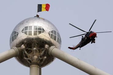 Belgian soldiers set up a Belgian flag on the top of Atomium in Brussels.